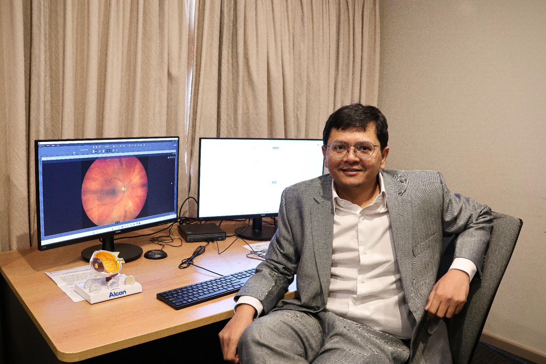 Dr Vaibhav Shah at his consulting desk reviewing a fundus image