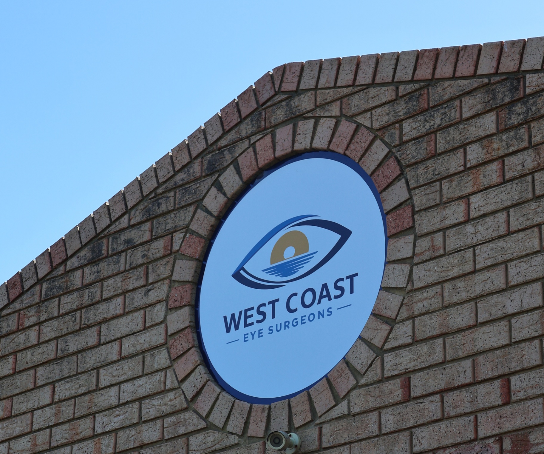 West Coast Eye Surgeons sign mounted on the brick exterior