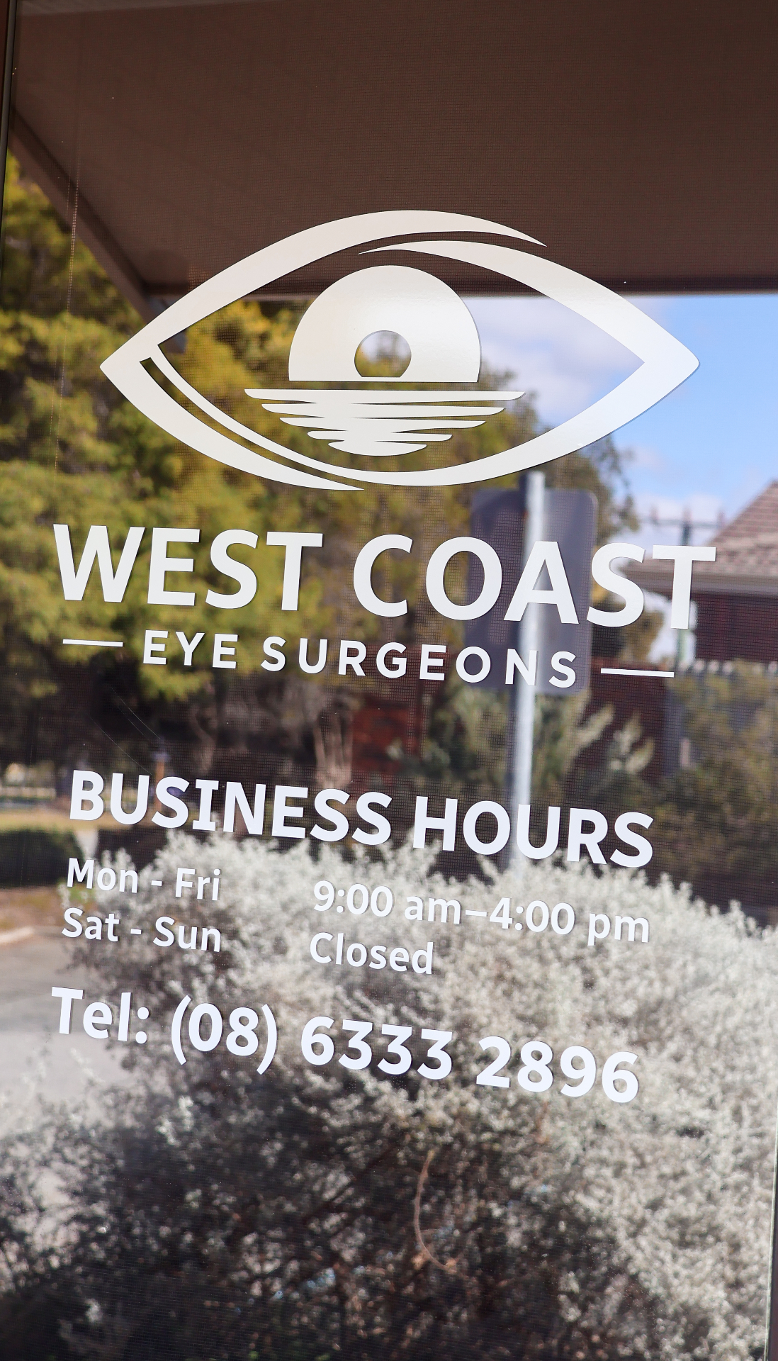 Window signage with West Coast Eye Surgeons logo and business hours
